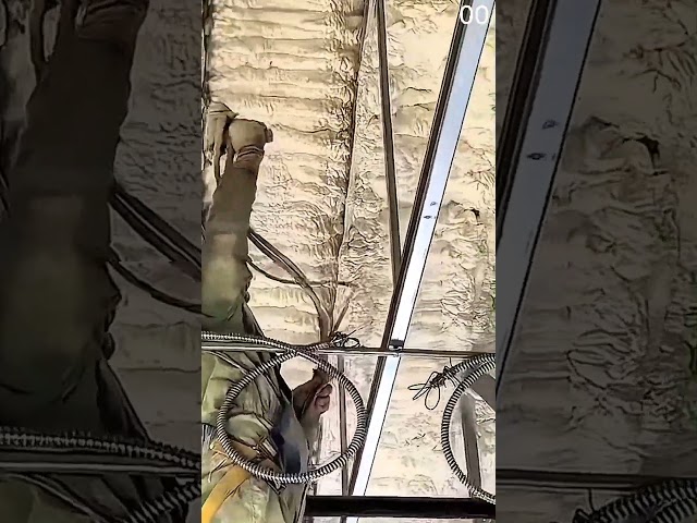 workers spray thick white insulation foam on metal roof #insulation #construction