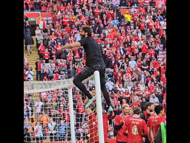 Alisson Becker climbs on the crossbar to celebrate the Prem with the Liverpool fans on the Kop!