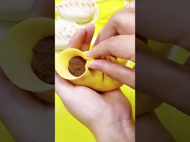 folding yellow dough around chocolate filling for dumplings #dumplings #dessert