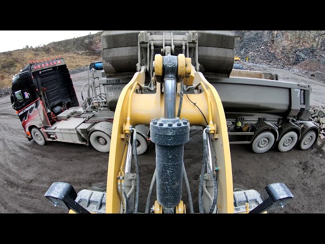 a day at work Caterpillar 972M XE wheel loaders loads truck and dumpers